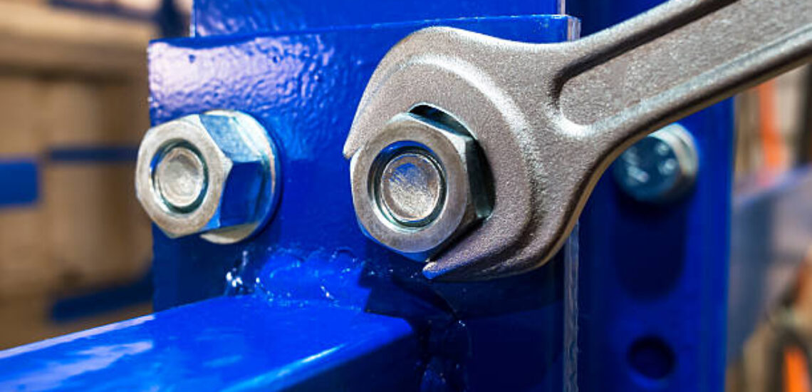 Wrench is tightening the chrome nut on the blue metal folding shelf Wrench is tightening the chrome nut on the blue metal folding shelf