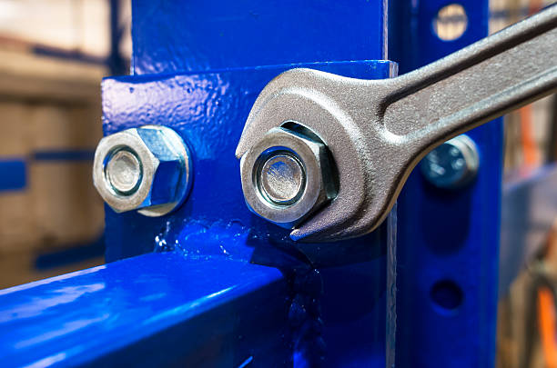 Wrench is tightening the chrome nut on the blue metal folding shelf