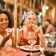 personas comiendo en un restaurante sonriendo